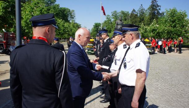 Sławomir Kowalewski i Leszek Ośliźlok dekorują strażaków medalami Zasłużony dla Miasta Mława