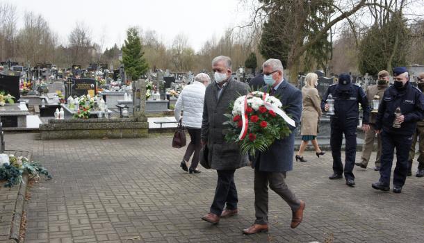 Składanie kwiatów i zniczy pod pomnikiem na cmentarzu parafialnym