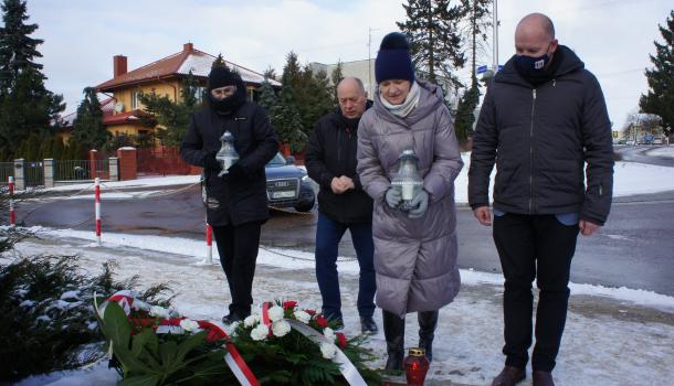 Cztery osoby składające znicze