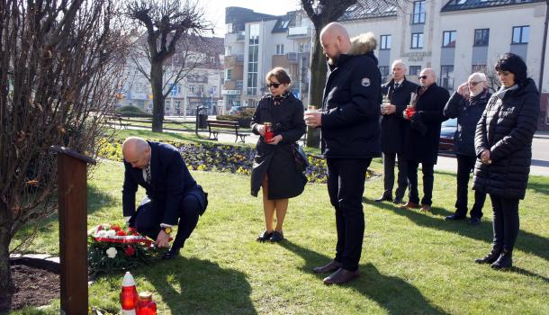 Kwiaty i znicze składają Burmistrz Miasta Mława Sławomir Kowalewski, Naczelnik Wydziału Komunikacji Społecznej i Medialnej Urzędu Miasta Mława Magdalena Grzywacz, Zastępca Burmistrza Miasta Mława Szymon Zejer i Dyrektor Miejskiego Domu Kultury w Mławie Edyta Suszek